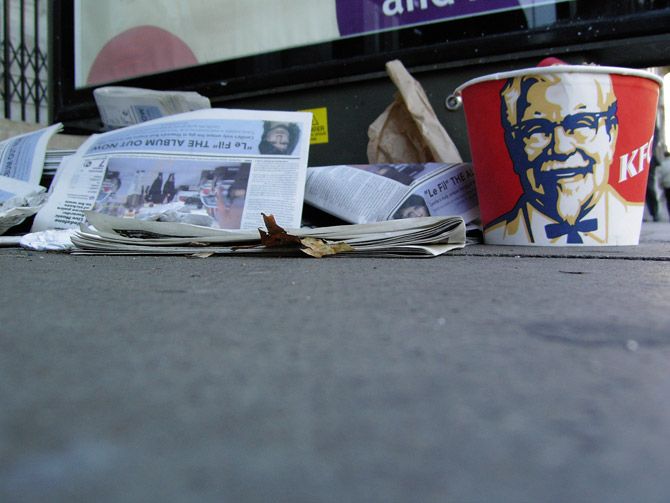 What do I need to balance the piles of discarded 'free' papers? Oh yeah, a KFC bucket!